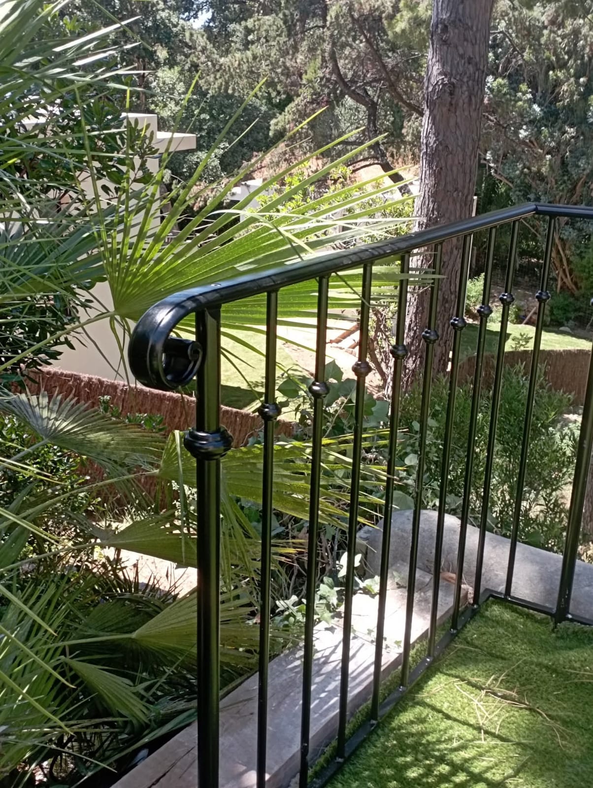 Garde-corps en fer forgé sur terrasse avec vue sur le jardin