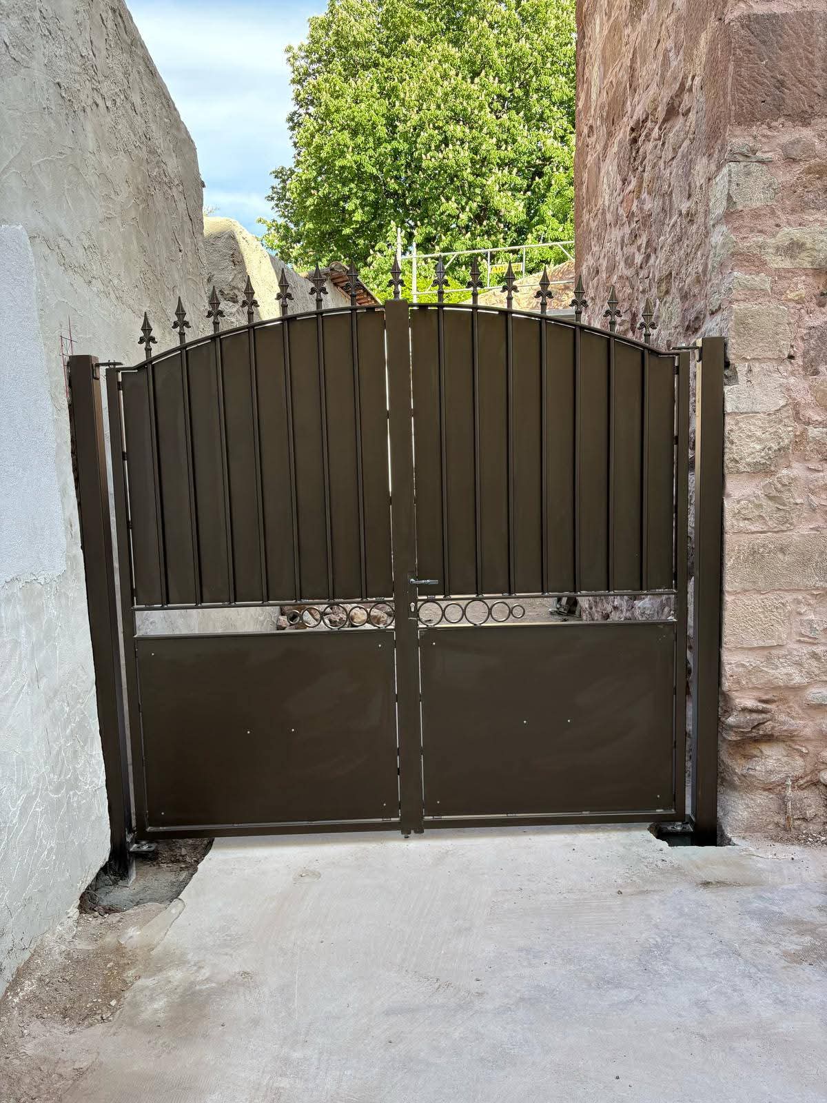 Portail double marron posé entre deux murs en pierre