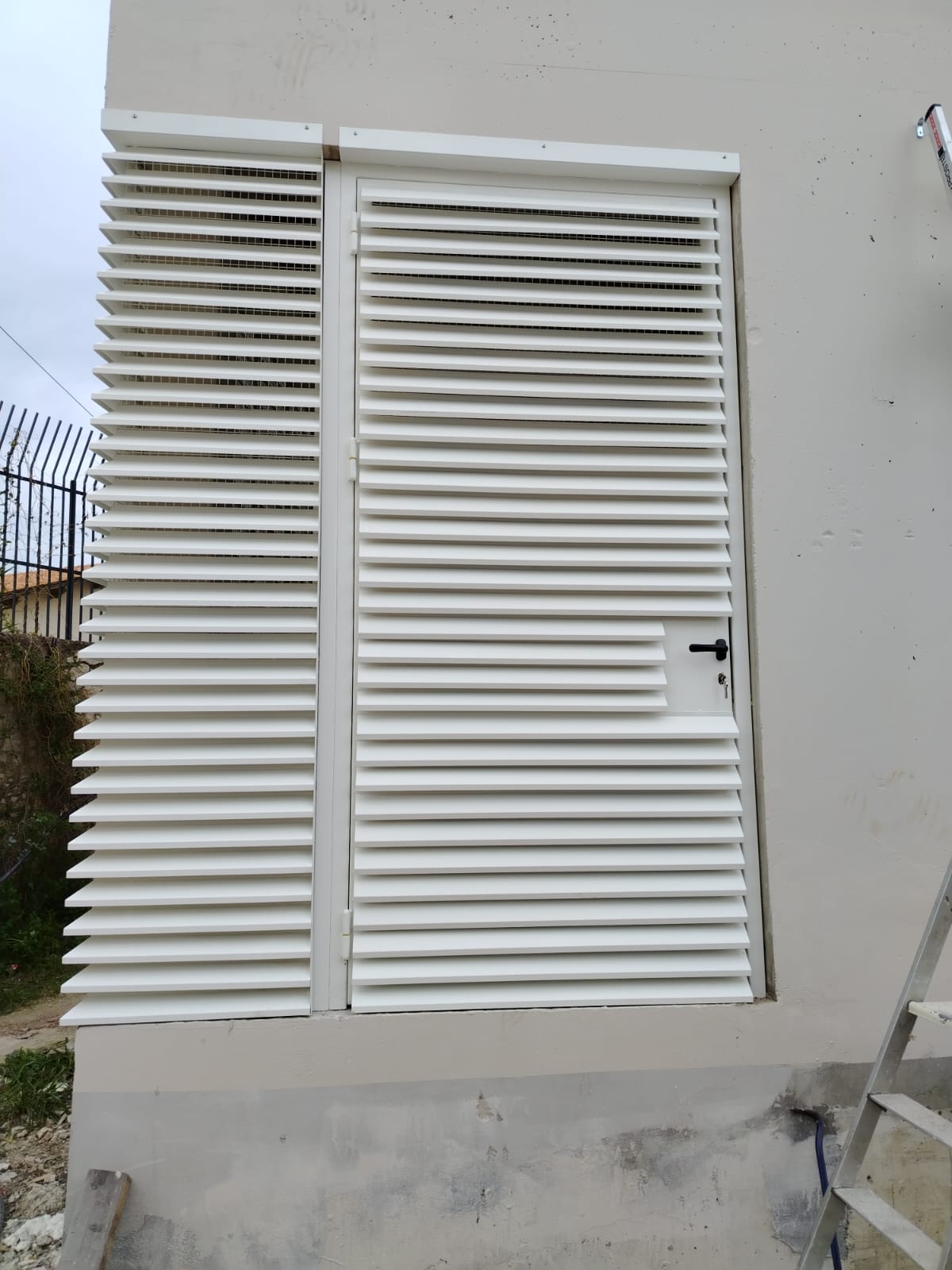 Porte métallique à persiennes blanches avec panneau fixe